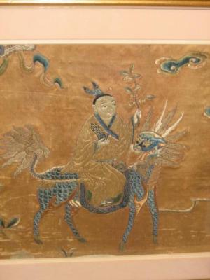 Appraisal: A CHINESE EMBROIDERED SILK PANEL depicting a deity riding a