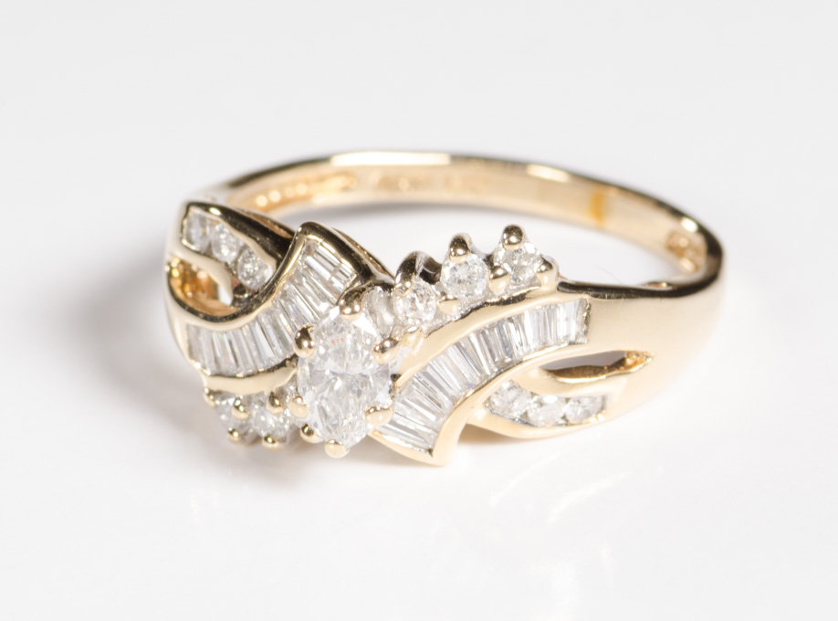 Appraisal: DIAMOND AND FOURTEEN KARAT GOLD RING with round-cut and baguette-cut