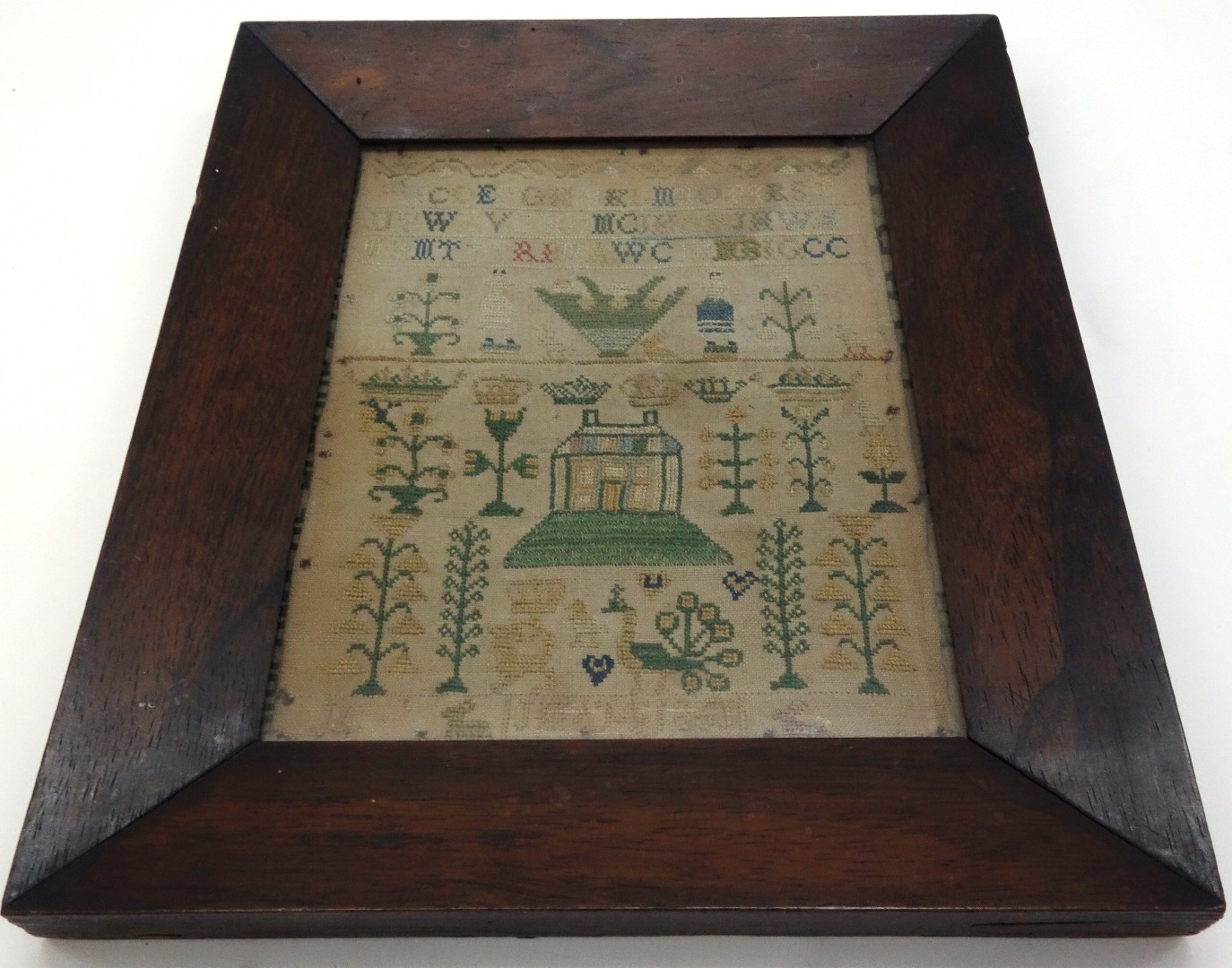 Appraisal: A needlework sampler worked with an alphabet figures topiary formal