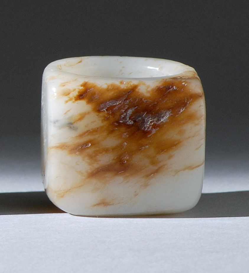 Appraisal: WHITE AND RUSSET JADE ARCHER'S RING th th CenturyWith one