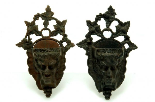 Appraisal: Two cast iron wall match safes of devil faces beneath