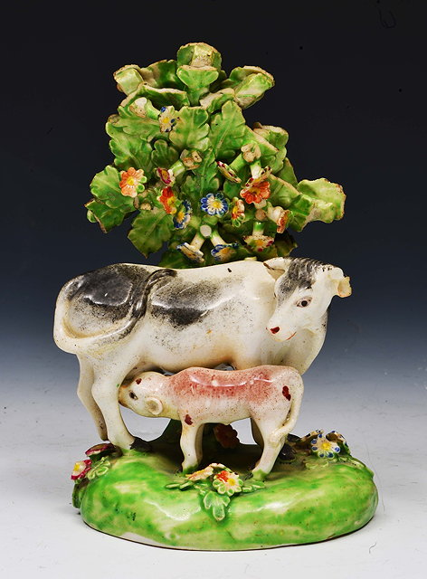 Appraisal: Staffordshire pottery model of a cow and calfset against a