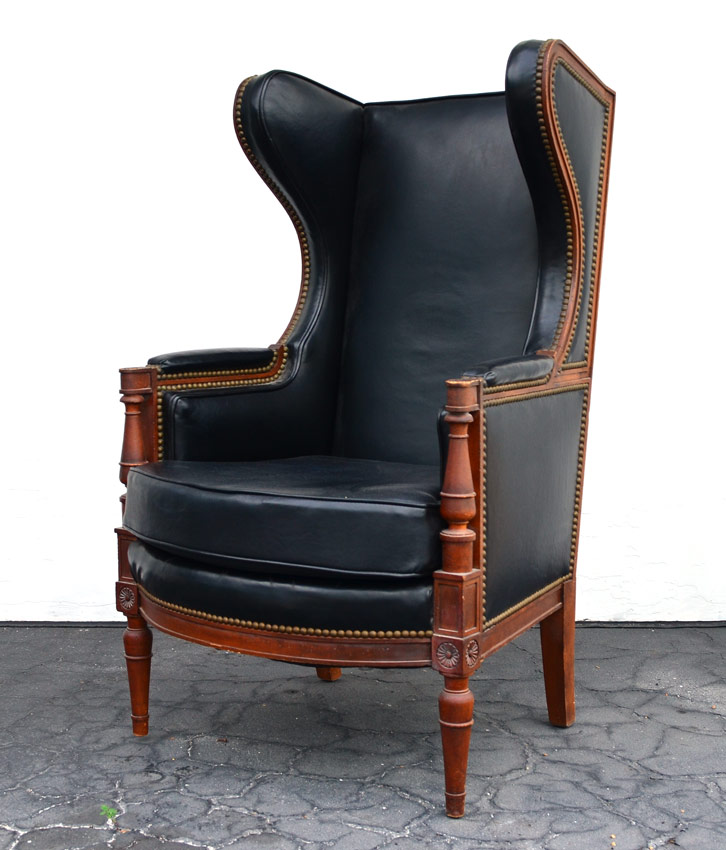 Appraisal: BLACK LEATHER WING BACK LIBRARY CHAIR Carved and shaped frame