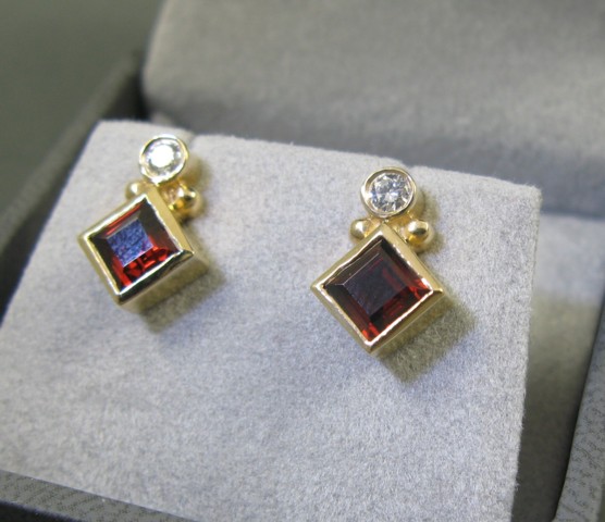 Appraisal: PAIR OF GARNET AND DIAMOND EARRINGS each set with a