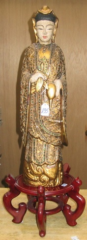 Appraisal: A CHINESE WOOD CARVED FIGURE depicting Quan Yin holding fruit