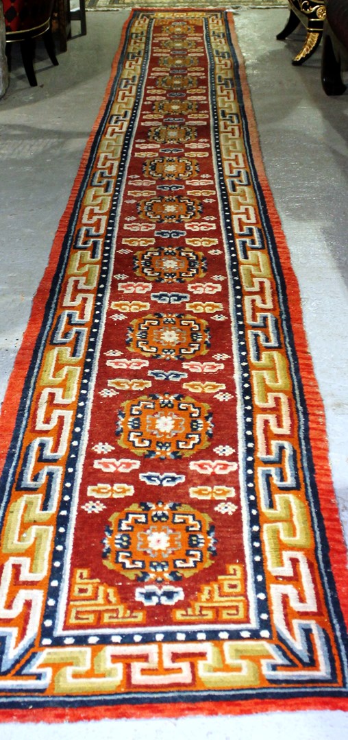 Appraisal: A Tibetan runner the madder field with twelve roundels x