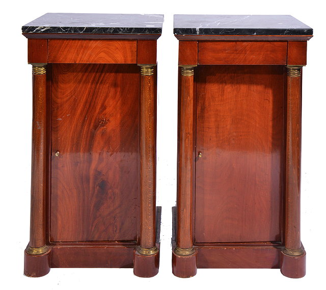 Appraisal: A PAIR OF EMPIRE STYLE MARBLE TOPPED MAHOGANY BEDSIDE CUPBOARDS