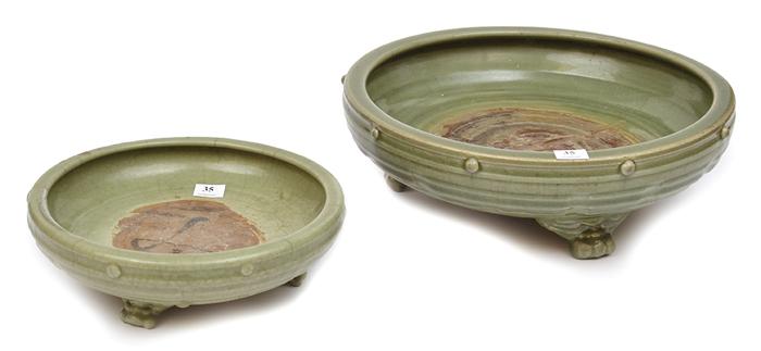 Appraisal: TWO SHALLOW CIRCULAR CELADON GLAZED EARTHENWARE FOOTED BOWLS