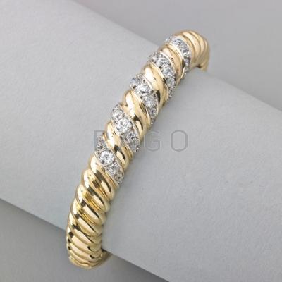 Appraisal: DIAMOND K GOLD HINGED BRACELET Designed as twisted rope centrally