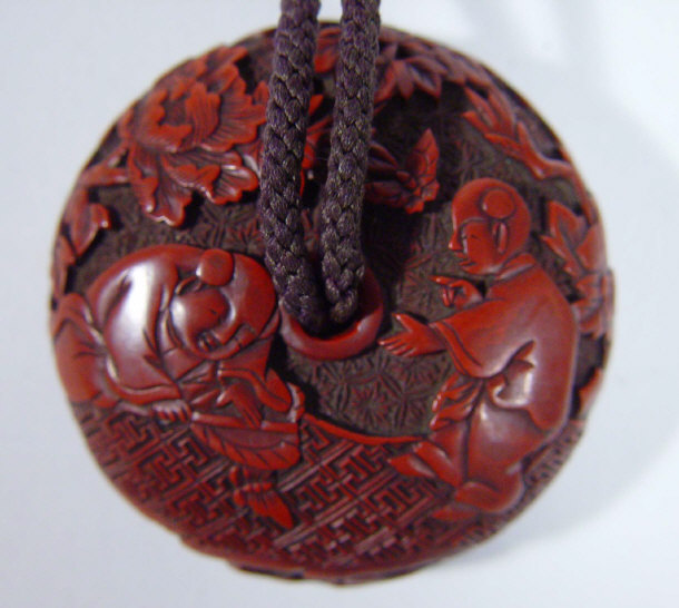 Appraisal: Oriental red lacquer toggle inset with a bronze scene of