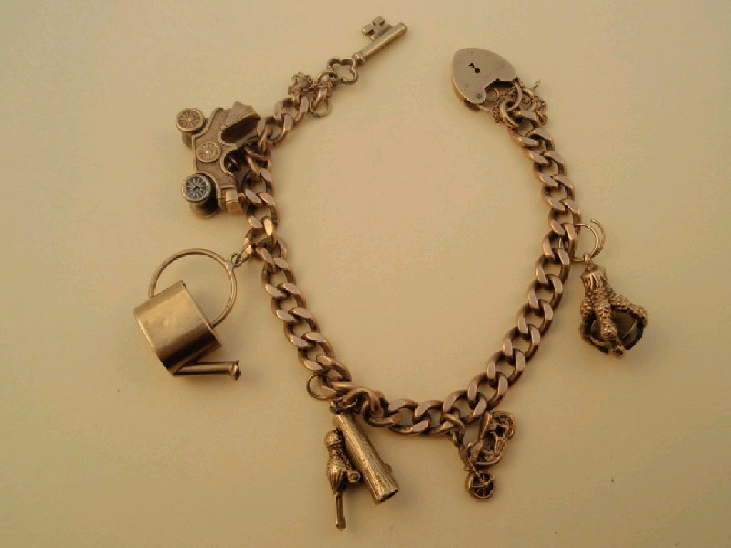 Appraisal: A curb link ct gold charm bracelet with six attached