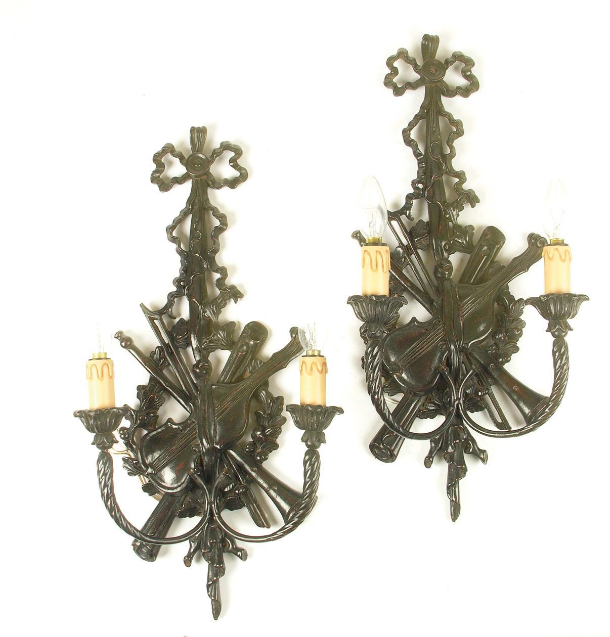 Appraisal: A pair of ebonised twin branch wall lights