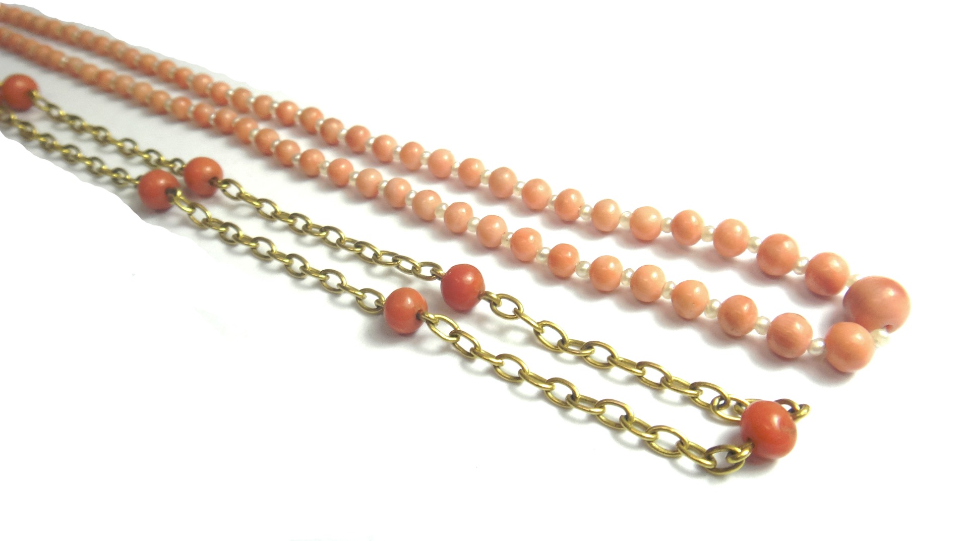 Appraisal: A gold and coral bead necklace the oval link chain