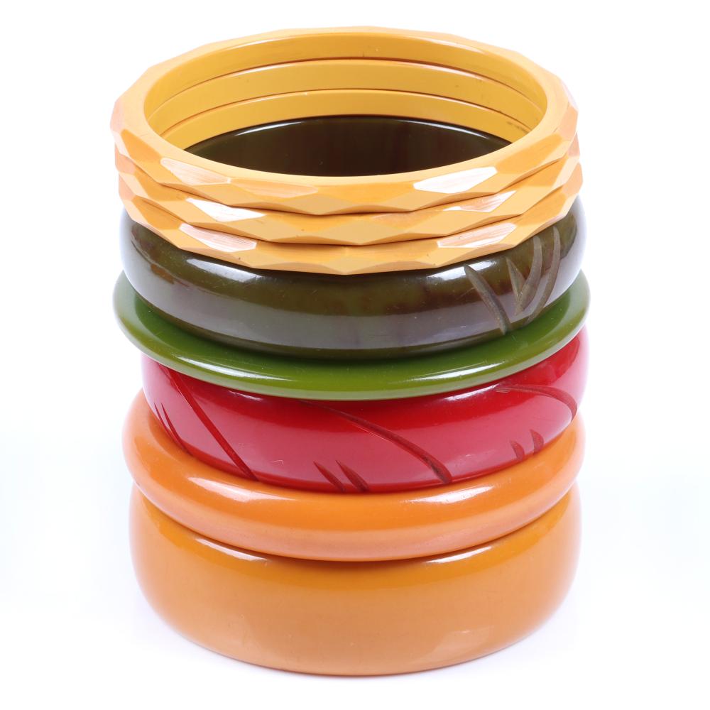 Appraisal: A TOWER OF BAKELITE BANGLE BRACELETS IN GREEN GOLD AND