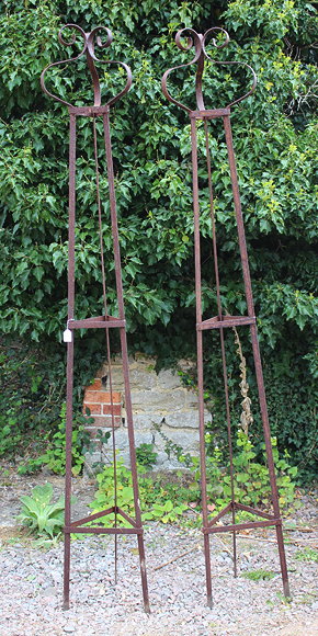 Appraisal: A PAIR OF WROUGHT IRON TRIANGULAR GARDEN OBELISKS with scrolling