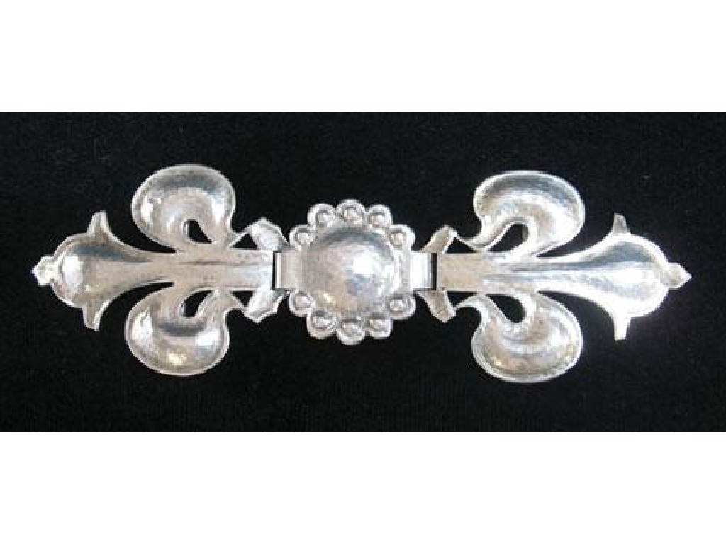 Appraisal: A SILVER MORSE in the form of a flowerhead flanked