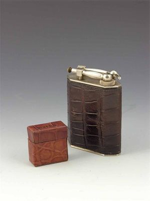 Appraisal: A crocodile covered table lighter with chrome mounts in cm