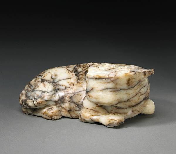 Appraisal: A mottled jade archaistic ox th Century Its recumbent body