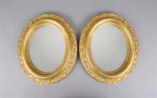 Appraisal: A Pair of Oval Giltwood Mirrors Length inches