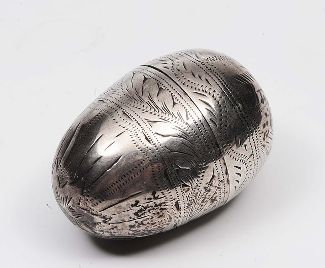 Appraisal: A Georgian nutmeg grater of egg-shaped formwith engraved and chased