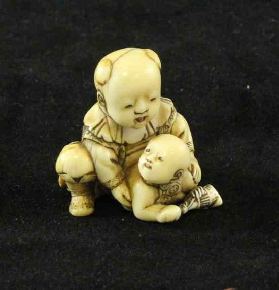 Appraisal: A Japanese ivory netsuke of a child holding a baby