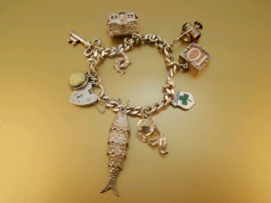 Appraisal: A silver charm bracelet with nine attached charms g all