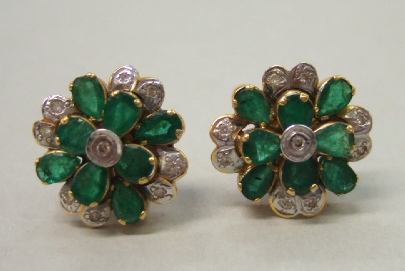 Appraisal: A pair of emerald and diamond set cluster earstuds each