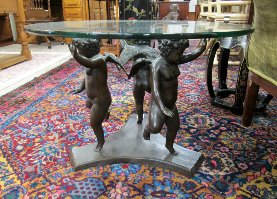 Appraisal: FIGURAL BRONZE-BASE COCKTAIL TABLE featuring a group of three winged