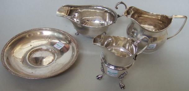 Appraisal: Silver comprising a sauceboat with a decorated rim raised on