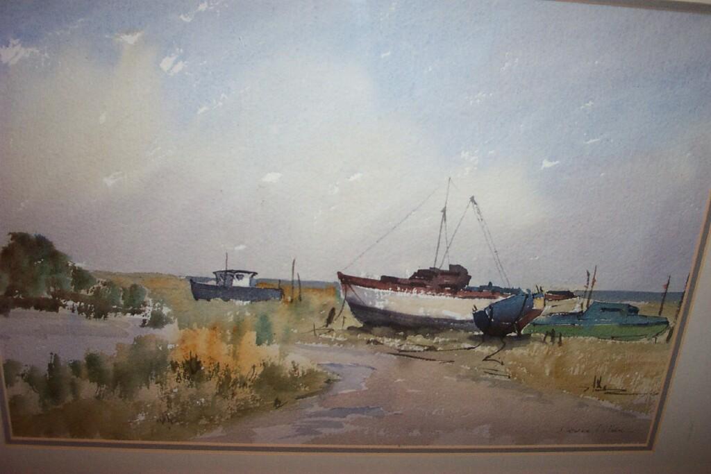 Appraisal: A watercolour of a Norfolk landscape with beached boats signed