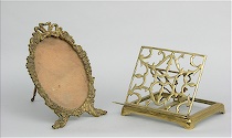 Appraisal: A Polished Brass Book Stand and a Fancy Brass Picture