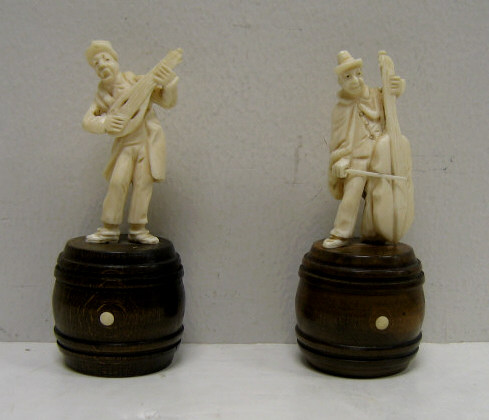 Appraisal: PAIR OF CARVED IVORY MUSICIAN FIGURES Each playing an instrument