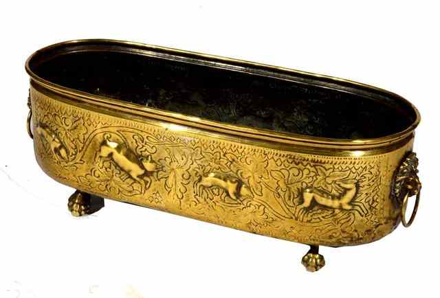 Appraisal: A BRASS PLANTER of oval form with stylised embossed animal