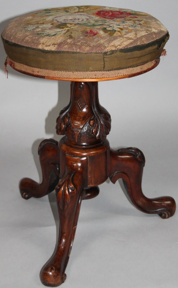 Appraisal: A Victorian walnut framed piano stool the circular top with