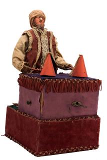 Appraisal: Conjuror Automaton Circa Elaborately dressed figure raises and lowers two