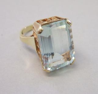 Appraisal: A gold ring mounted with a rectangular step cut aquamarine