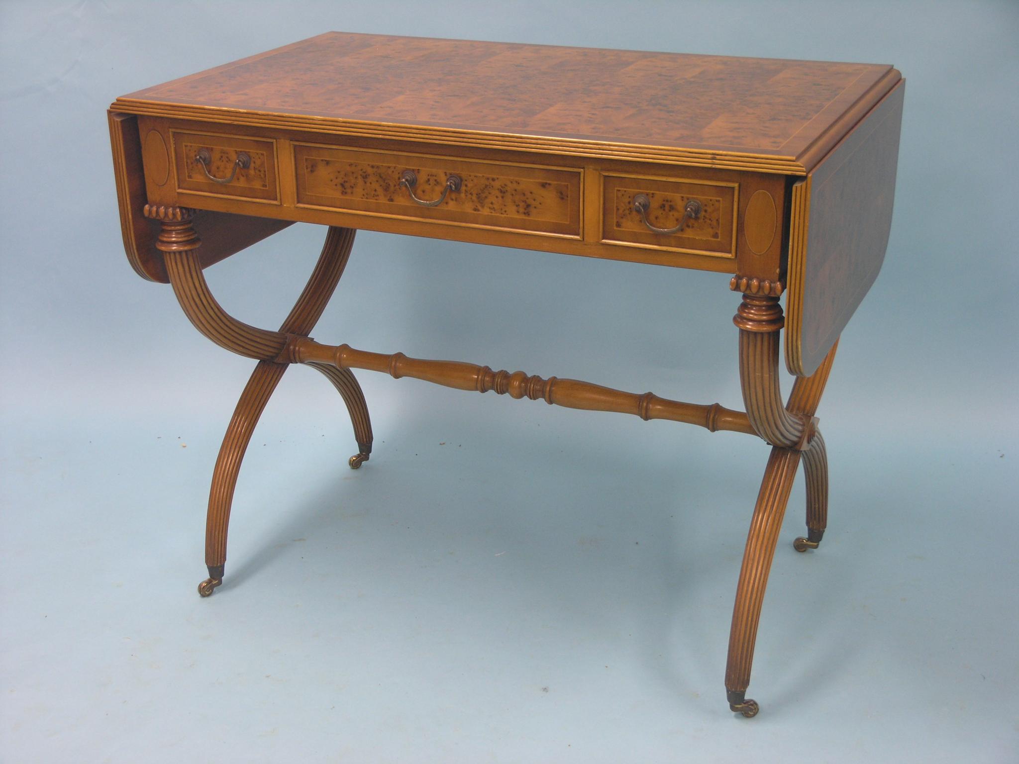 Appraisal: A reproduction burr yew-veneered sofa table with three frieze drawers