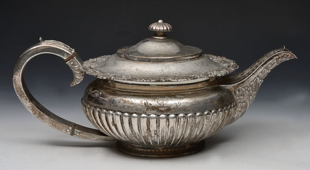 Appraisal: A GEORGE V SILVER TEAPOT circular shaped with fluted lower