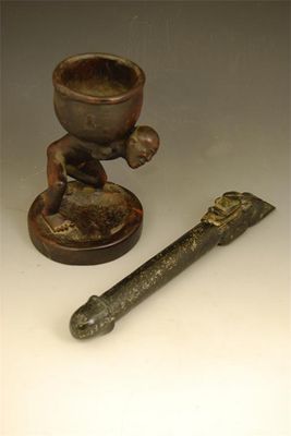 Appraisal: A carved green stone phallus with a kneeling figure with