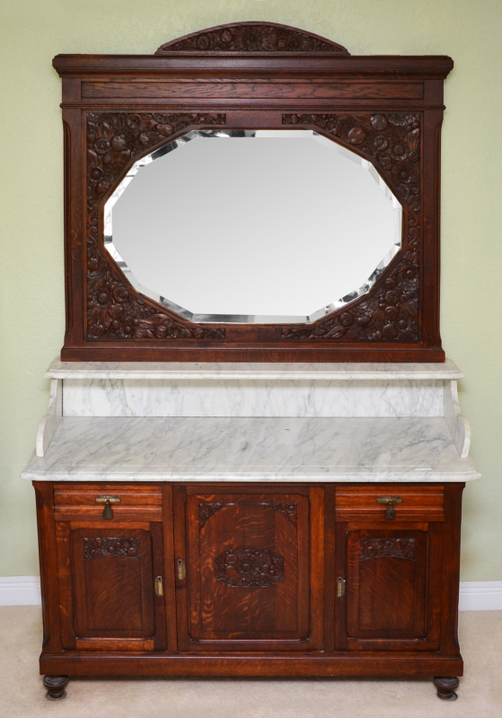 Appraisal: MARBLE TOP CARVED OAK WASHSTAND Profusely carved beveled glass mirror