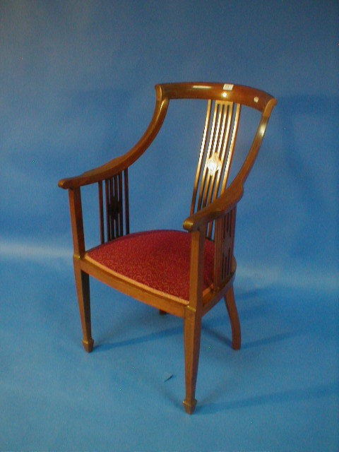 Appraisal: An Edwardian string inlaid mahogany high back tub chair