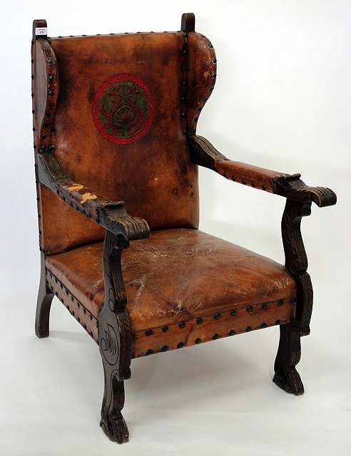 Appraisal: A LEATHER UPHOLSTERED WING BACK OAK FRAMED OPEN ARMCHAIR with