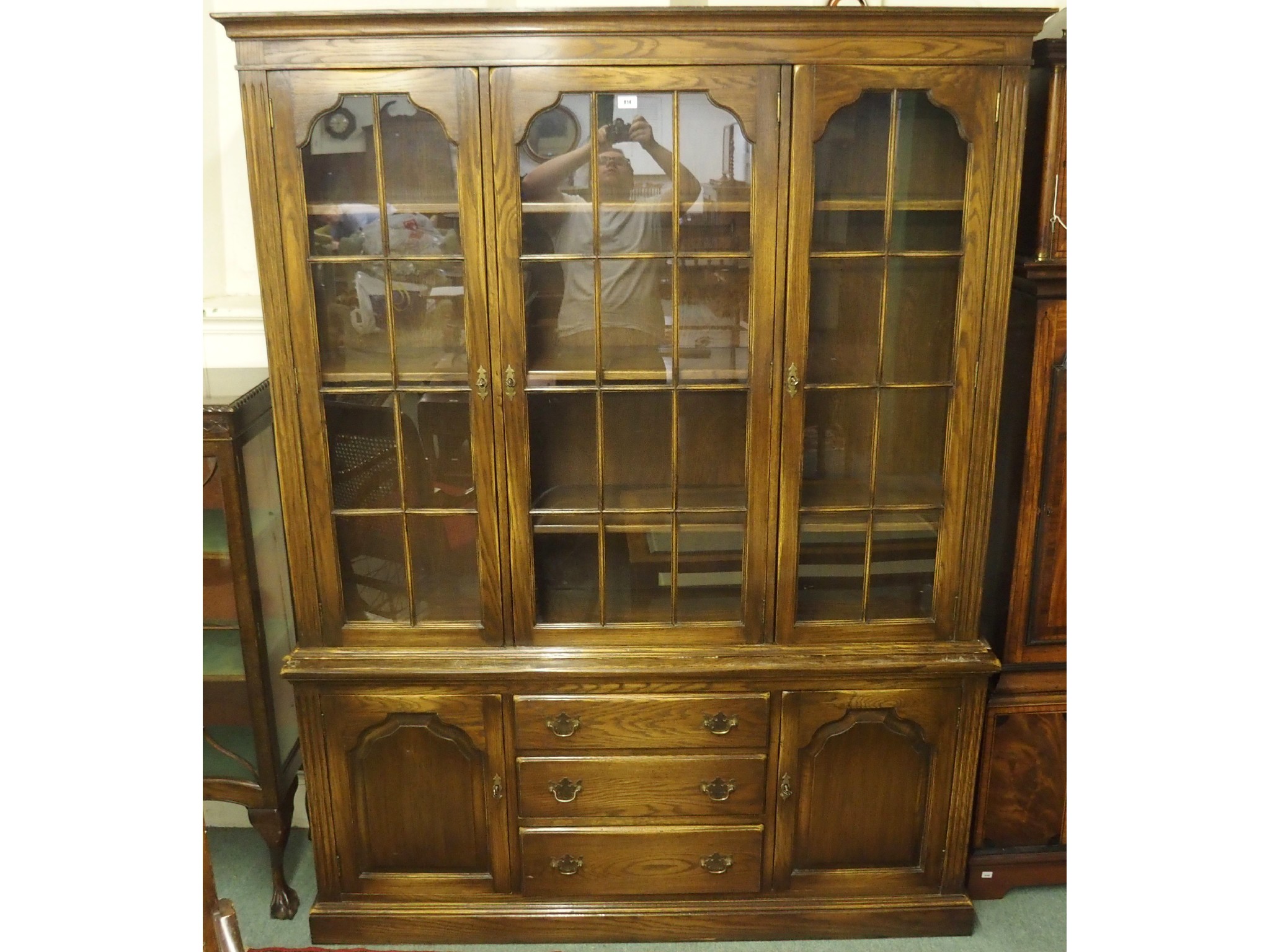 Appraisal: A th Century oak three glazed door bookcase over two