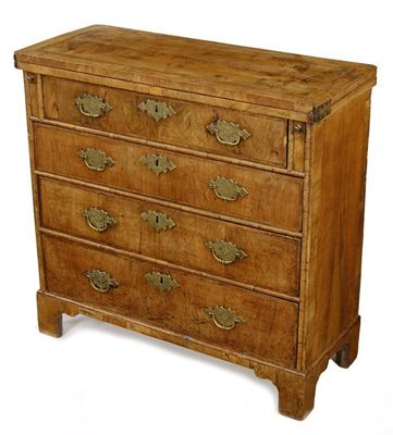 Appraisal: A walnut bachelor's chest the quarter veneered cross and feather