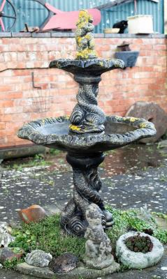 Appraisal: A two-tier fountain with putto finial and entwined dolphin supports