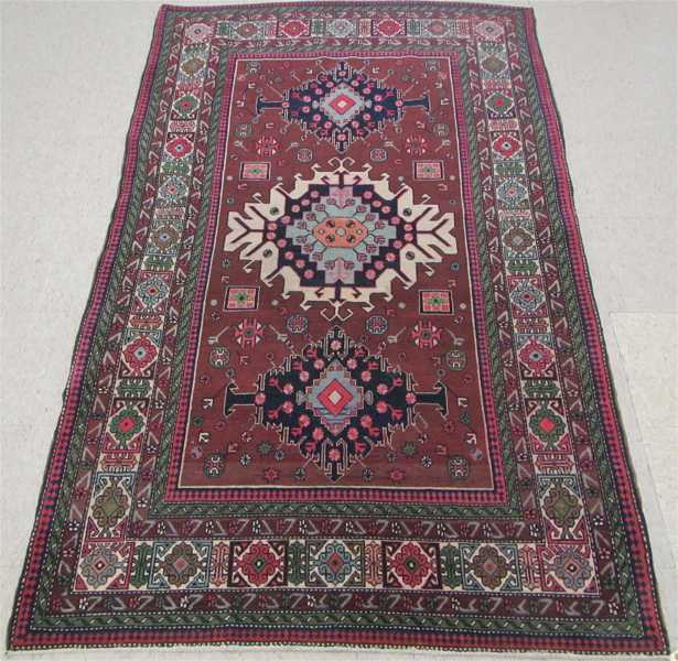 Appraisal: SEMI-ANTIQUE PERSIAN AREA RUG three geometric medallion design on plum