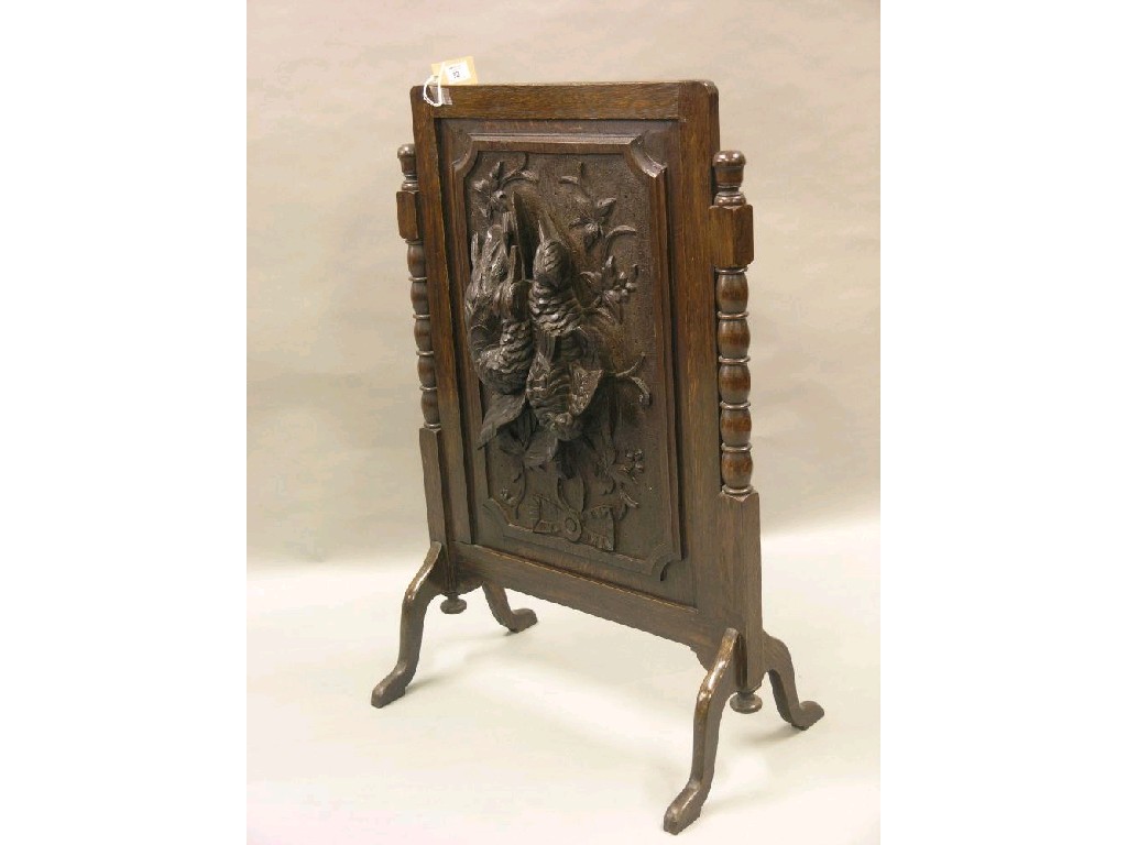 Appraisal: An unusual dark carved oak firescreen the single panel carved