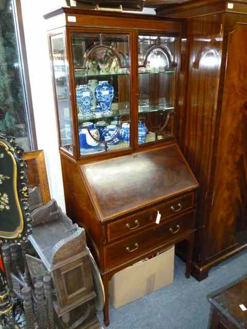 Appraisal: A MAHOGANY BUREAU BOOKCASE the upper section with bevelled glass