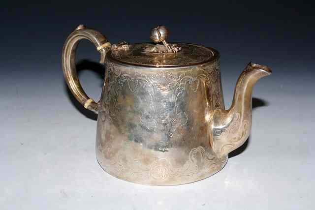 Appraisal: A VICTORIAN SILVER TEAPOT with a tapering body engraved with