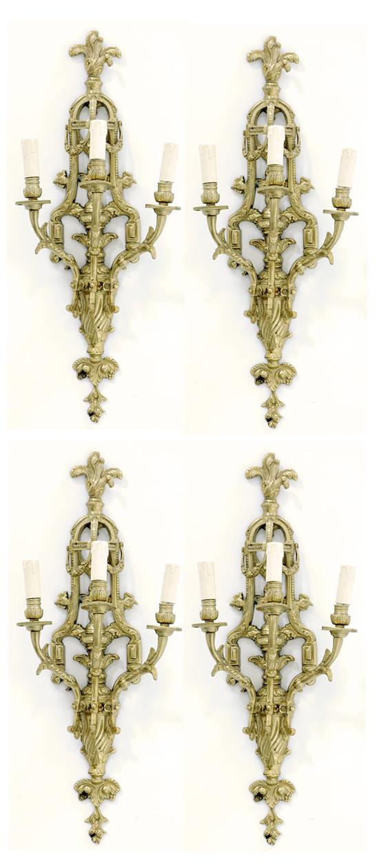 Appraisal: Four gilt-metal three-light wall sconces pierced and scrolling urn-form backplate